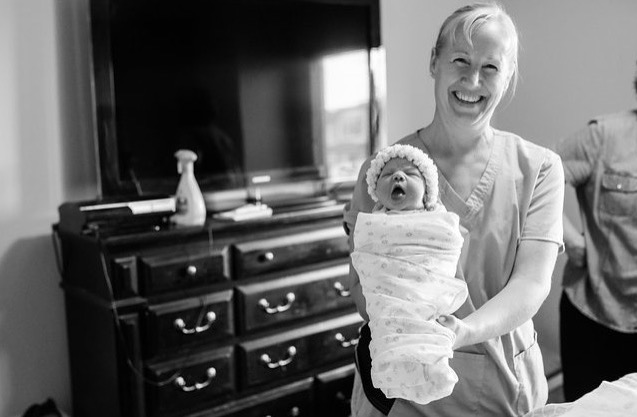 Tara Stephens, Midwife and Owner of Beautiful Births Homebirth Midwifery Practice in Colorado Springs, CO holding a newborn.