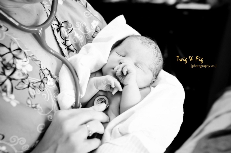 Tara Stephens, Midwife and Owner of Beautiful Births Homebirth Midwifery Practice in Colorado Springs, CO holding newborn baby and checking heart rate with stethoscope. 