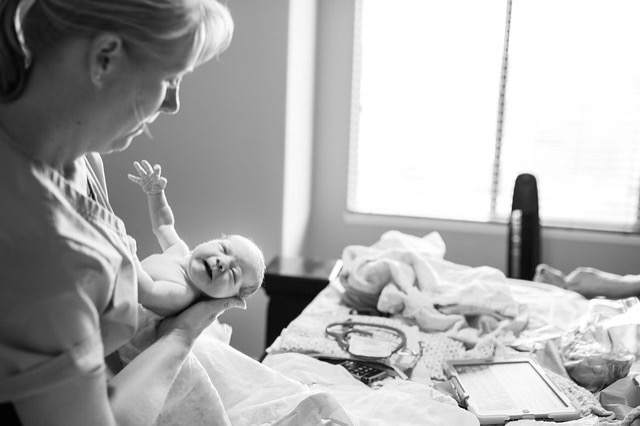  Tara Stephens, Midwife and Owner of Beautiful Births Homebirth Midwifery Practice in Colorado Springs, CO giving newborn baby wellness check.